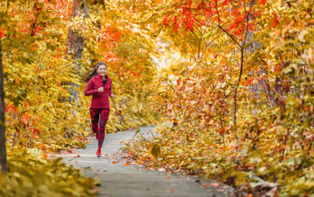 Woman running through fall scene, in recovery from an eating disorders