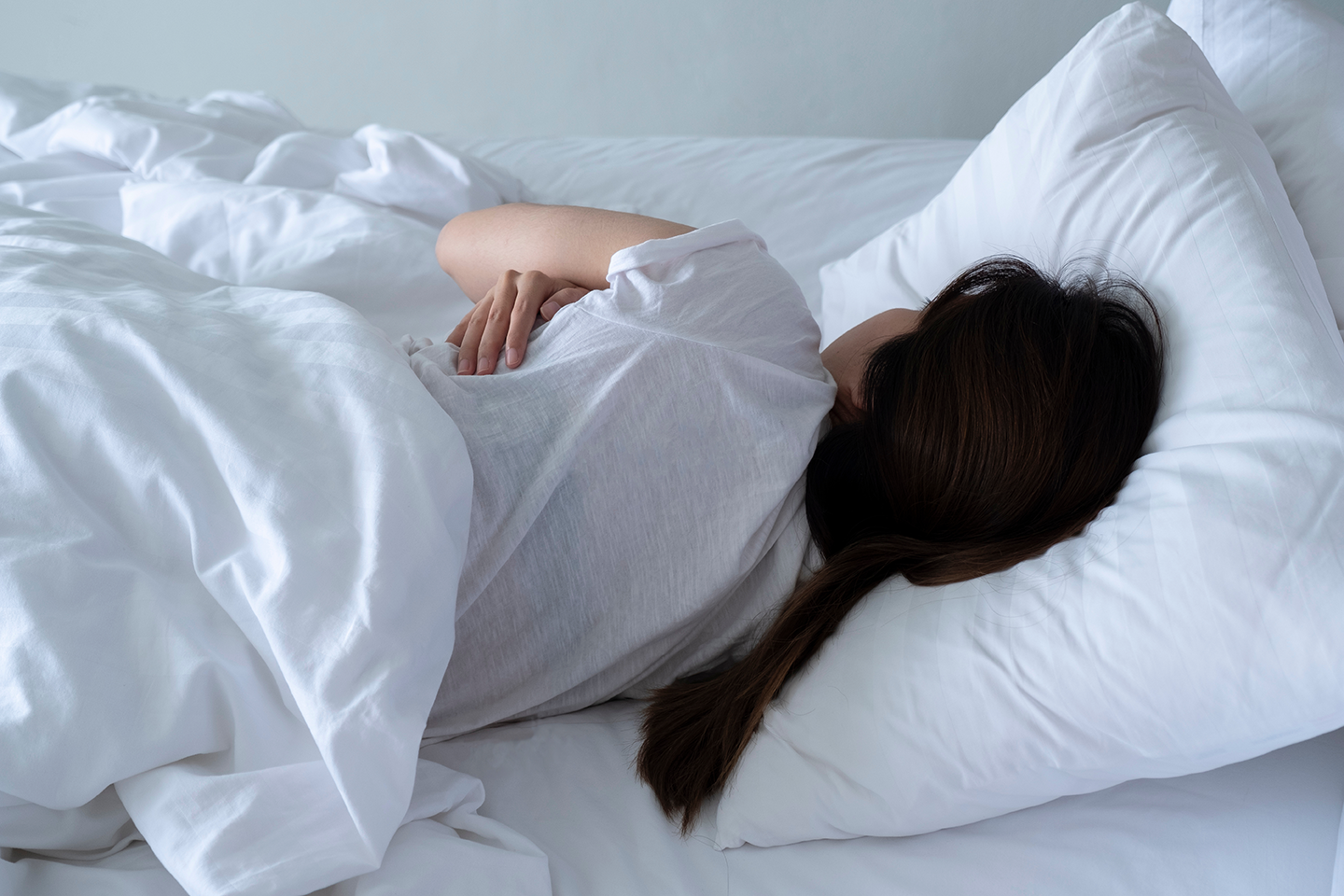 Woman lies in bed taking a rest day