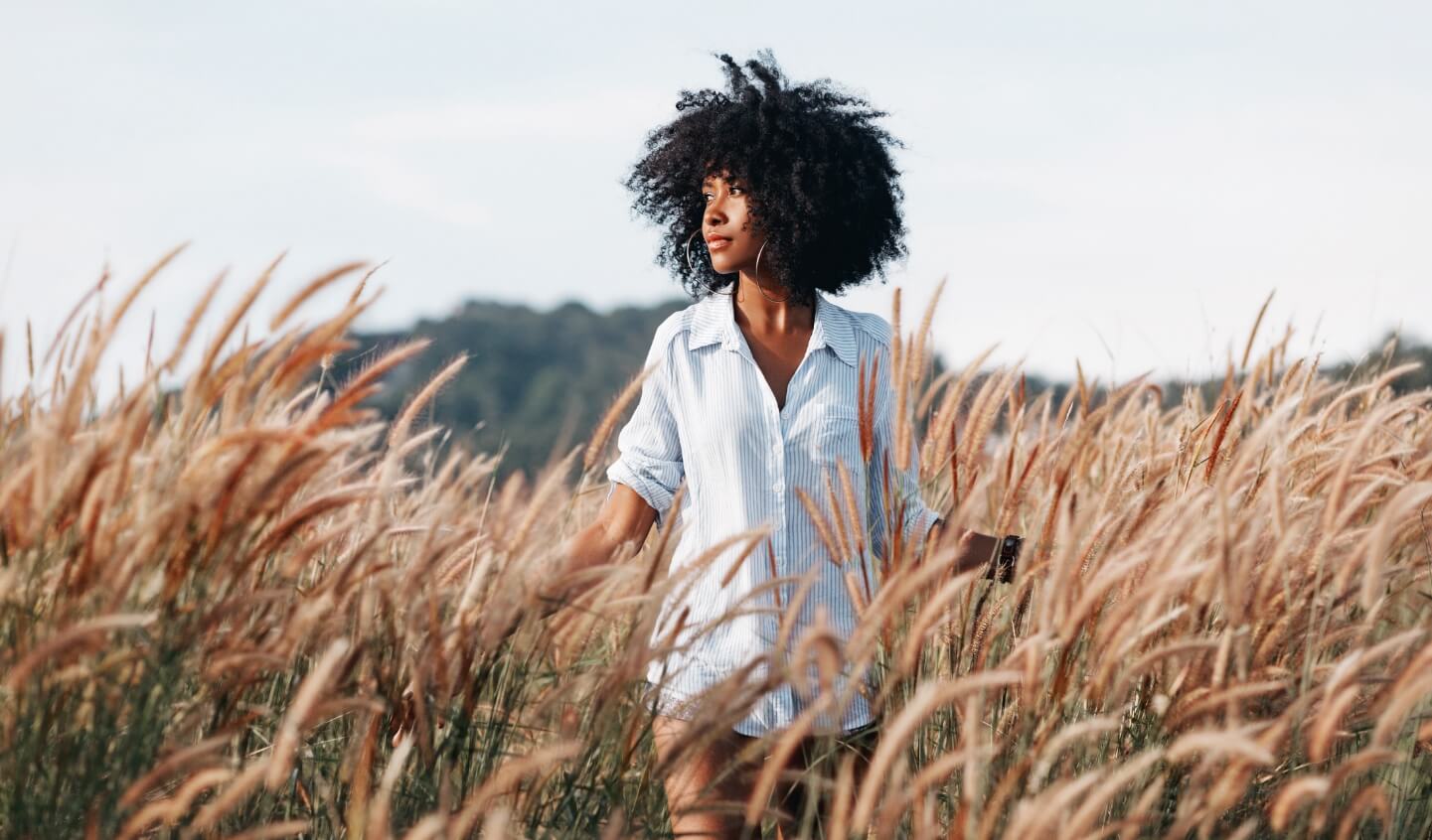 A nutrition counseling client walks through a field of wheat.
