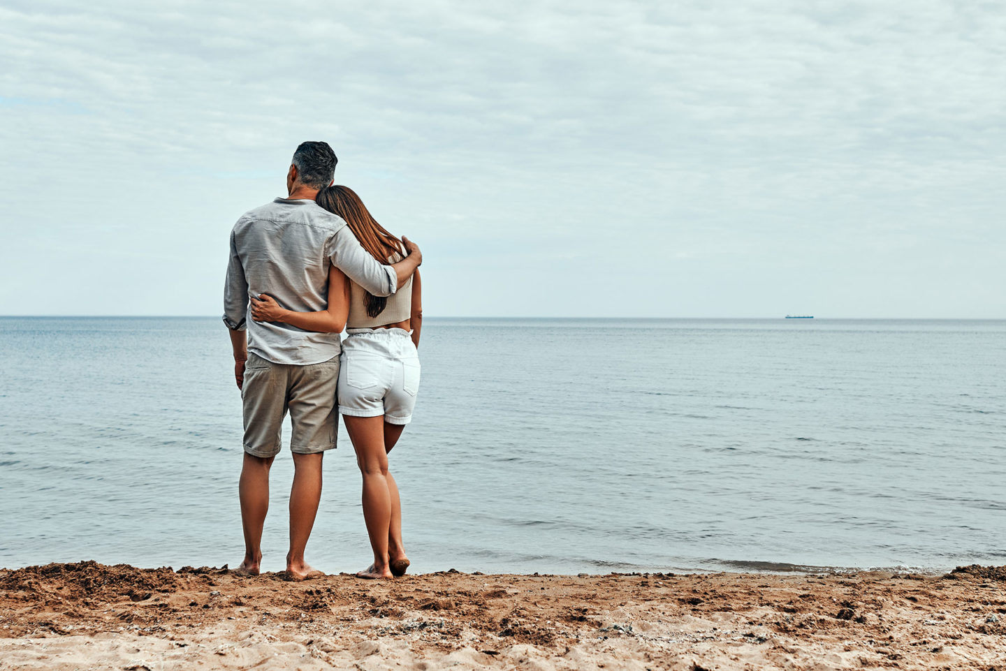 Couple with arms around each other on beach